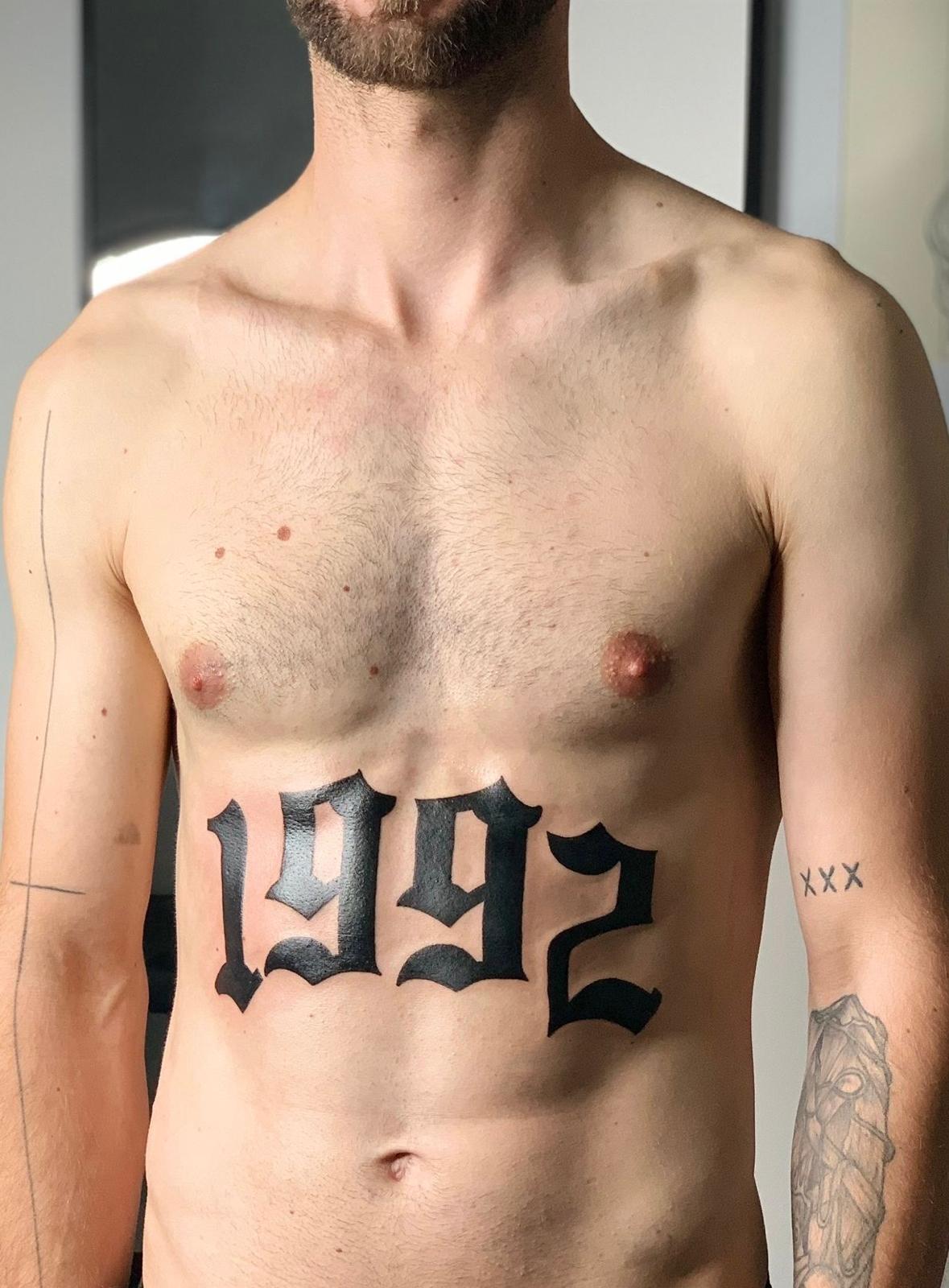 Jahreszahl 1992 als Bauch-Tattoo in Frakturschrift
