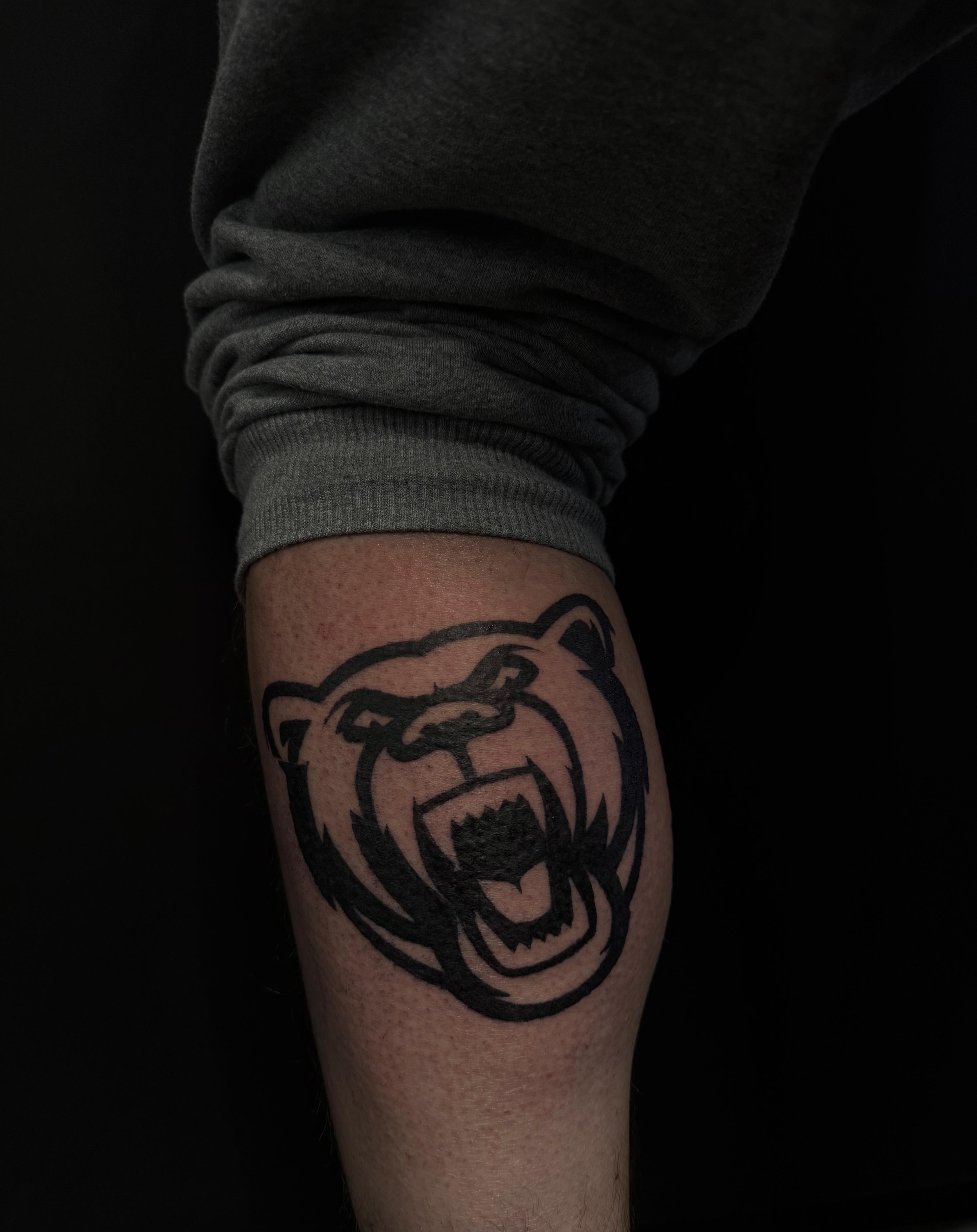 Blackwork Bären-Logo Tattoo, Oberarm
