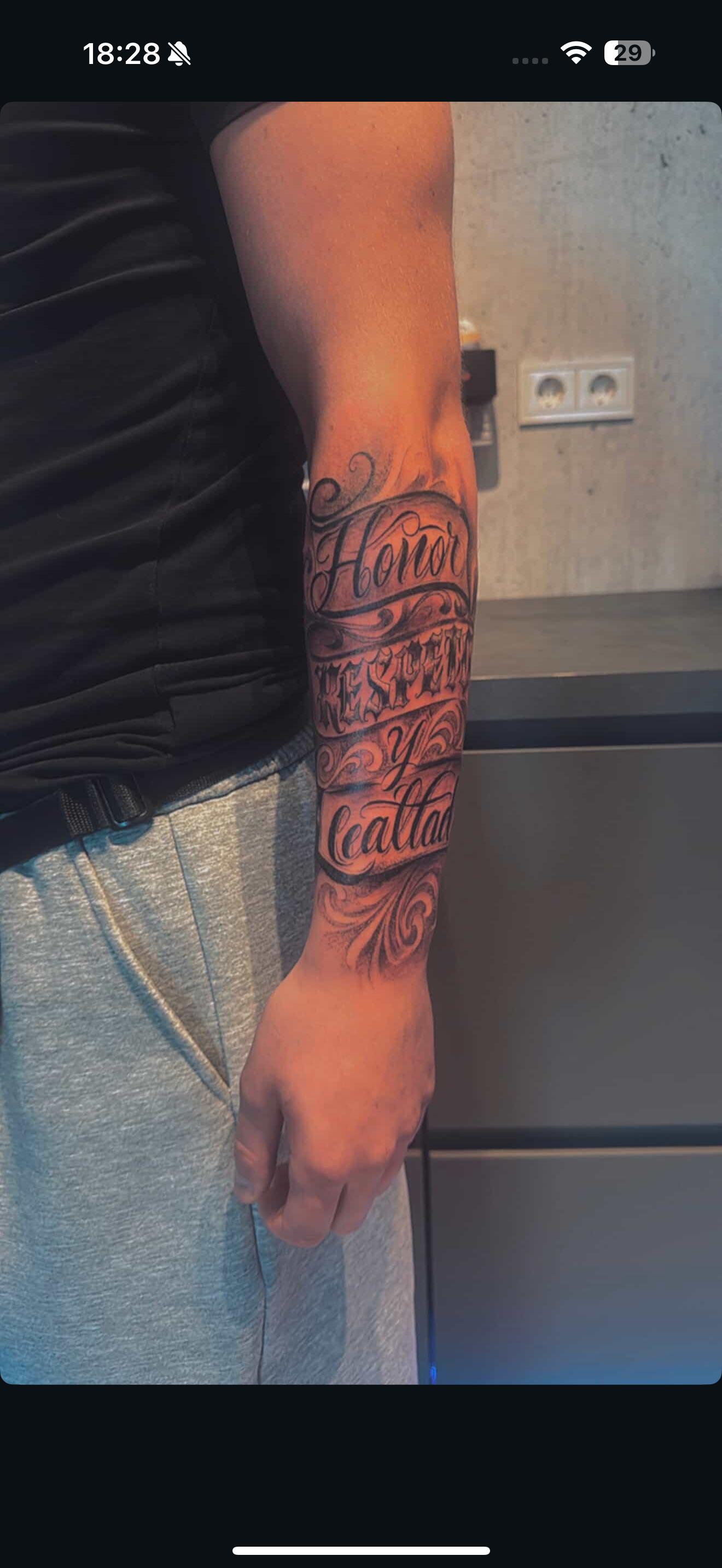 Großes Lettering-Sleeve am Unterarm, schwarz-grau