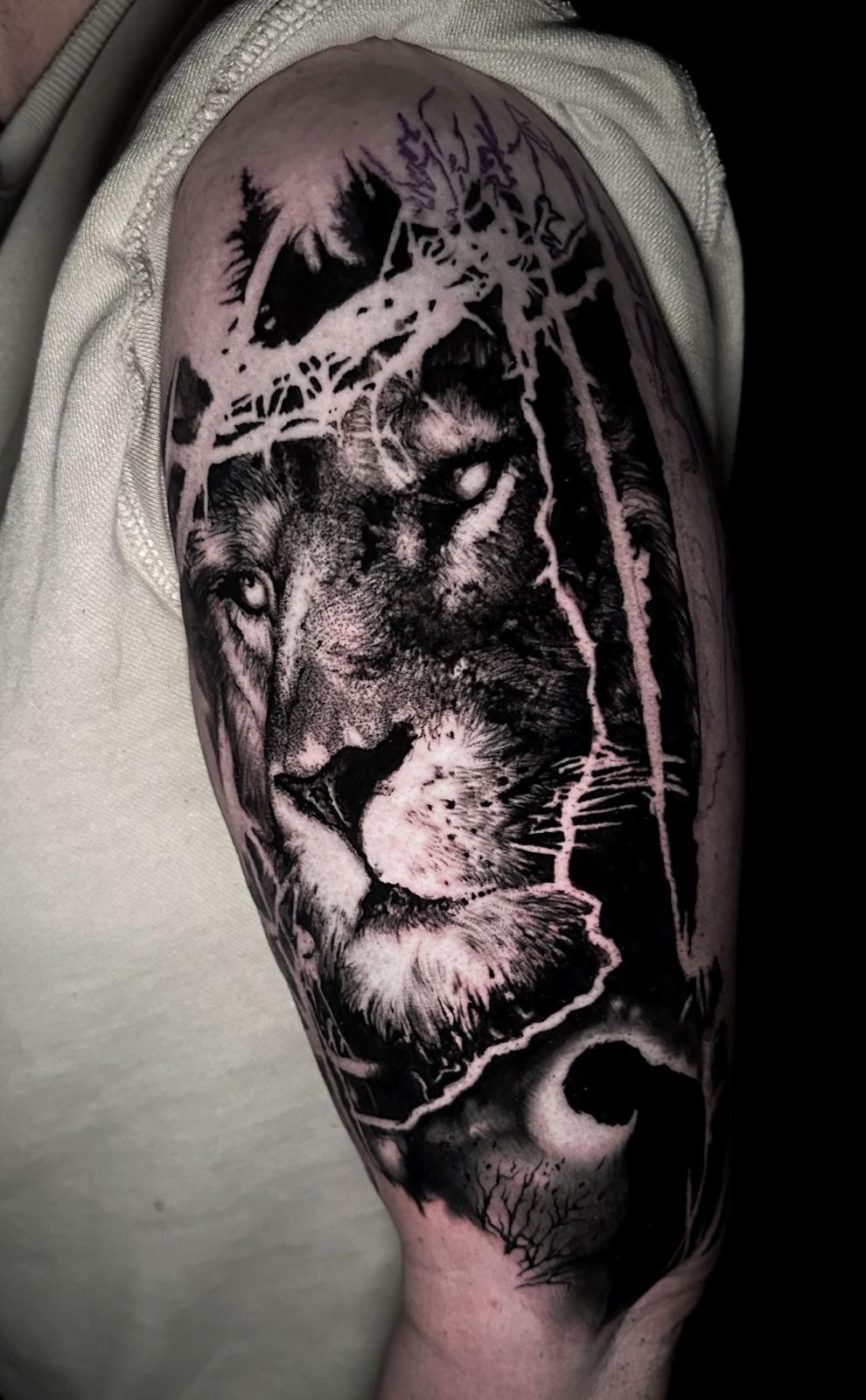 Realistischer Löwenkopf mit Wald-Silhouette, Oberarm schwarz-grau